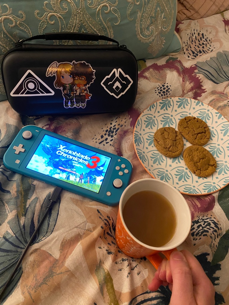 Xenoblade Chronicles 3 start menu on Nintendo Switch Lite, with fall cookies, apple cider, and Switch case with Xenoblade Chronicles 3 stickers